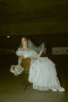 a woman in a wedding dress sitting on a chair