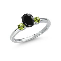 an oval black diamond and green peridolite three stone ring in white gold on a white background