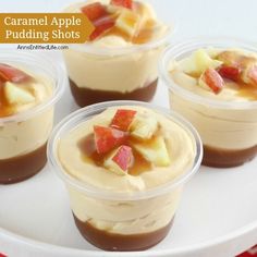 four cups filled with caramel apple puddings on top of a white platter