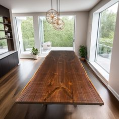 a large wooden table sitting in the middle of a living room next to a window