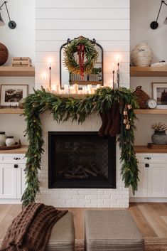 a fireplace decorated with greenery and candles