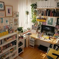 a home office with lots of plants and pictures on the wall