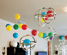 some colorful balls hanging from the ceiling in a room with a computer desk and television