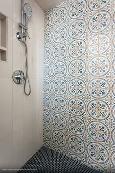 a bathroom with blue and white tiles on the shower wall