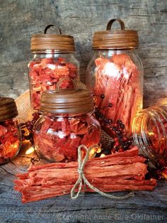 several jars filled with different types of dried fruit and vegetables next to each other on a wooden surface