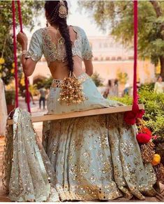 a woman is sitting on a swing with her back turned to look like she's having fun