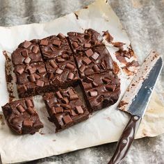 a piece of chocolate cake sitting on top of a paper towel next to a knife