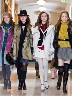 four models walking down the runway in coats and hats, all wearing knee high boots