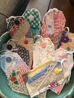 a bowl filled with lots of different types of fabric and buttons on top of a wooden table