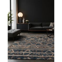 a living room with black walls and an area rug that has a blue design on it