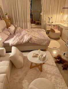 a bedroom with white furniture and lots of pillows on the bed, along with two teddy bears