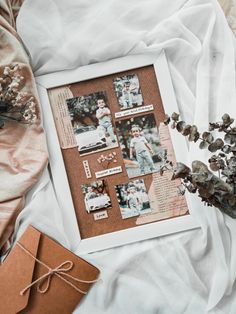 an old photo is displayed in a white frame next to some dried flowers and a notepad