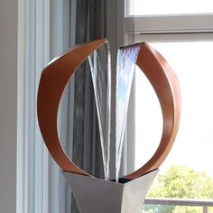 a metal sculpture sitting on top of a window sill next to a large window