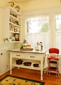 a kitchen with a table, chairs and shelves filled with food on top of it