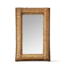 a mirror that is sitting on top of a white wall and has a brown frame