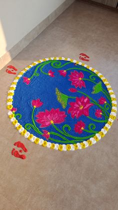 a blue rug with pink flowers on it in the middle of a living room floor