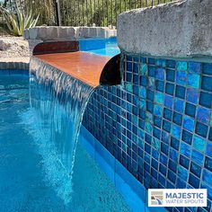 a pool with blue tiles and water flowing from it