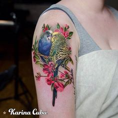 two parakeets sitting on a branch with pink flowers and green leaves tattoo by marina cuba