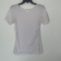 This White Basic Elastic Sleeve Teeshirt From Color Story Is A Must-Have For Your Wardrobe. It Has Only Been Worn Once To Try On And Is In Brand New Condition, Making It A Great Find. The Classic White Color Makes It Versatile And Easy To Pair With Any Outfit, While The Elastic Sleeves Add A Touch Of Style And Comfort. Whether You're Running Errands Or Going Out With Friends, This Teeshirt Is The Perfect Choice. Made With High-Quality Materials, It Is Durable And Long-Lasting, Ensuring That It Will Be A Staple In Your Closet For Years To Come. Don't Miss Out On This Opportunity To Add A Brand New, Stylish Piece To Your Collection. Grab This Color Story White Teeshirt Today And Elevate Your E Casual White Stretch Blouse, Stretch Cotton Crew Neck Blouse, White Stretch Basic Short Sleeve Top, White Fitted Scoop Neck Top, Stretch Short Sleeve Shirt For Everyday, White Stretch Short Sleeve Top For Spring, White Fitted Short Sleeve Top For Everyday, White Spring Short Sleeve Top With Scoop Neck, White Scoop Neck Short Sleeve Top For Spring