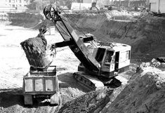 an old black and white photo of a construction site with a crane on it's back