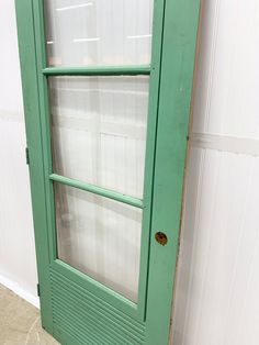 an old green door with glass on it