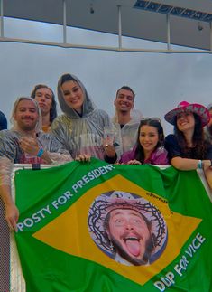 a group of people posing for a photo with a flag in front of them and the caption's name on it