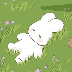 a white teddy bear laying in the grass