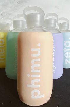 four water bottles with the word vitamin on them are lined up against a white background