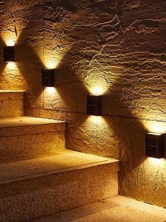 some lights that are on the side of stairs