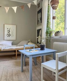 a living room with a blue table and some pictures hanging on the wall above it