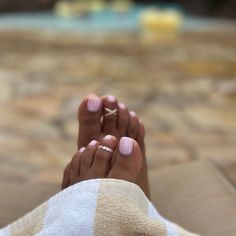 a woman's feet with two rings on her toes and one ring in the middle