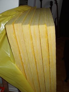 a pile of yellow paper sitting on top of a wooden floor next to a wall