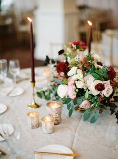 the table is set with candles and flowers