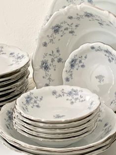 a stack of white and blue plates sitting on top of a table next to each other