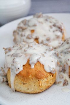 three biscuits covered in white icing on a plate