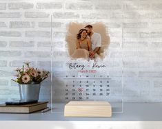 a personalized glass calendar with a photo on it and a wooden block next to it