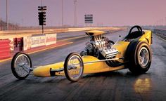 a yellow race car is on the track with its hood up and engine in the air