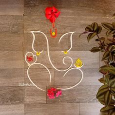 an artistic ganeshi decoration on the floor with flowers and leaves in front of it