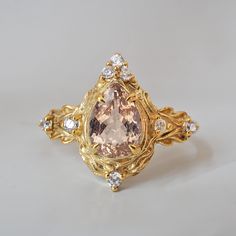 a fancy ring with an orange stone surrounded by white and yellow diamonds on a gray background