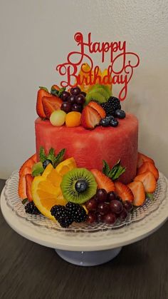 a birthday cake decorated with fruit and the words happy birthday