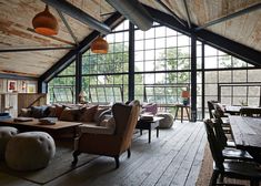 a large open living room with wooden floors and high ceilings, windows on the wall to let in natural light