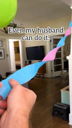 a person holding a blue toothbrush in front of a house with the caption even my husband can do it