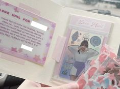 a person holding up a pink and white brochure with pictures on the inside