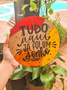 a person holding up a frisbee that says tudo ja fau la fum