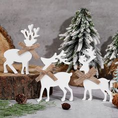 three wooden reindeers with bows and pine cones