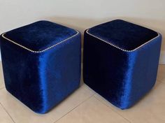 pair of blue velvet cube ottomans with gold studs