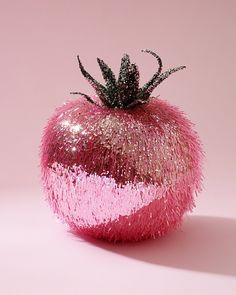 a pink and silver glitter apple on a pink background