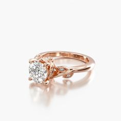 a rose gold engagement ring with an oval diamond in the center and two small diamonds on each side