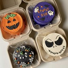 four halloween themed cupcakes in plastic containers