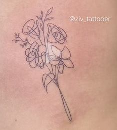 a woman's stomach has a tattoo with flowers on the side, and an arrow